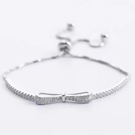 Silver bracelet with bow design on a white background